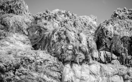 Multiple cubes of compressed plastic garbage near the waste recycling factory in open air